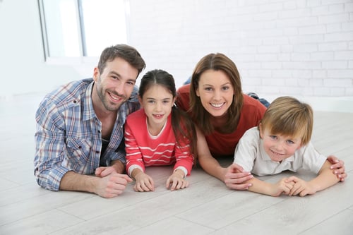 Happy family of four laying on the floor