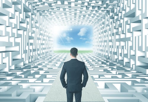 Successful businessman in front of a complicated labyrinth