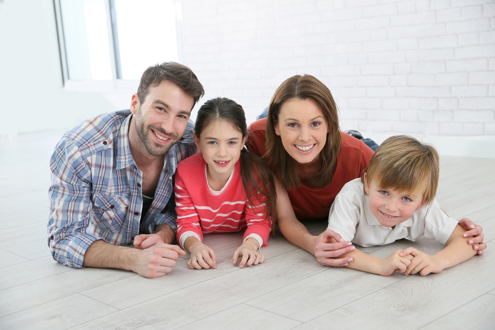 Happy family of four laying on the floor