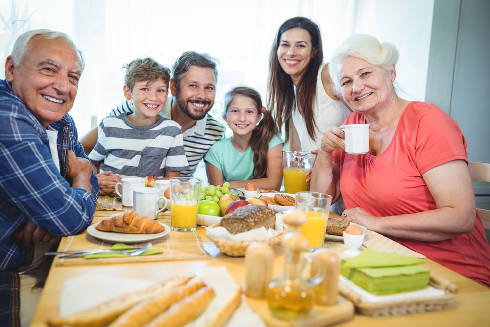 Portrait of happy multi-generation family sitting at breakfast table in home-1