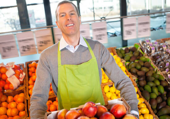 grocery store employee stocking fruit in the produce section